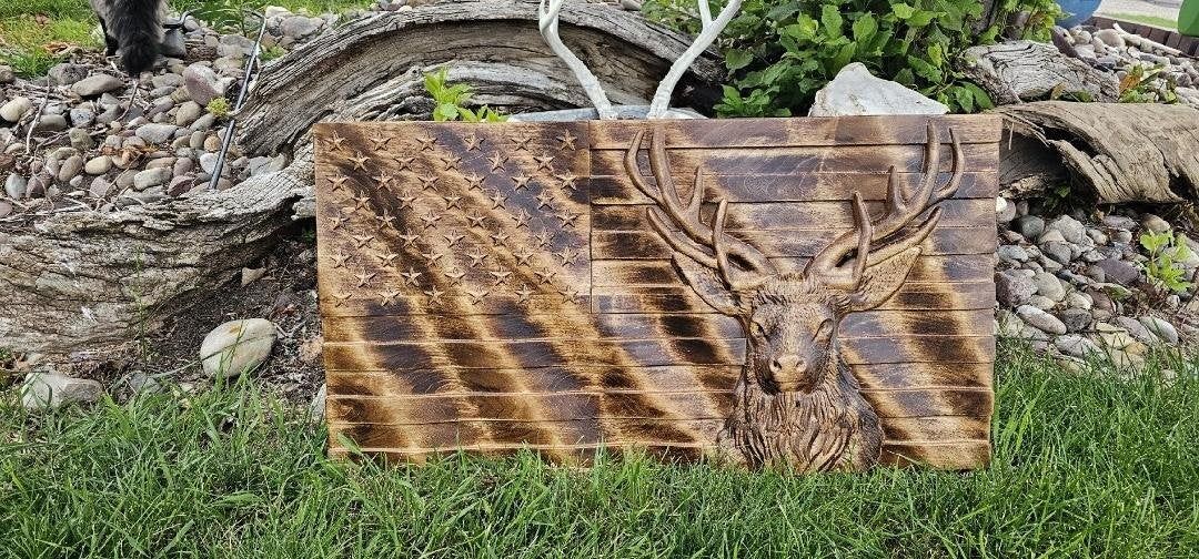 3D carved wavy American flag with a whitetail deer head in high relief, photographed outdoors