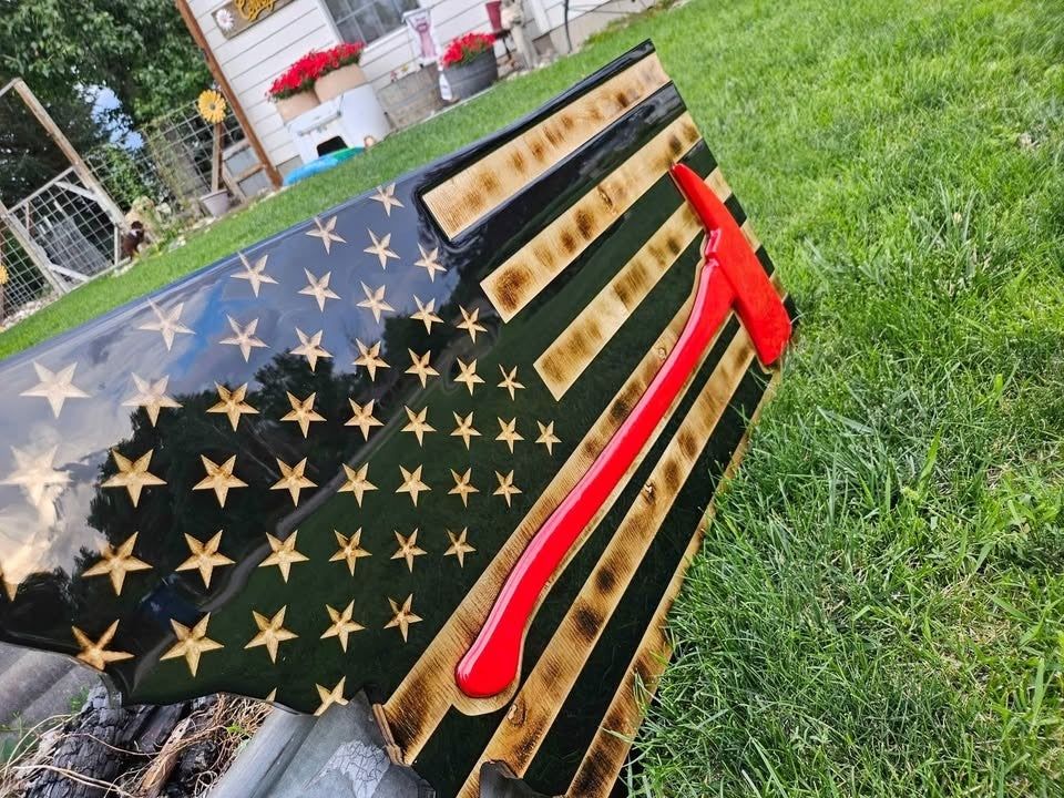 Montana-shaped firefighter flag photographed outdoors on the grass