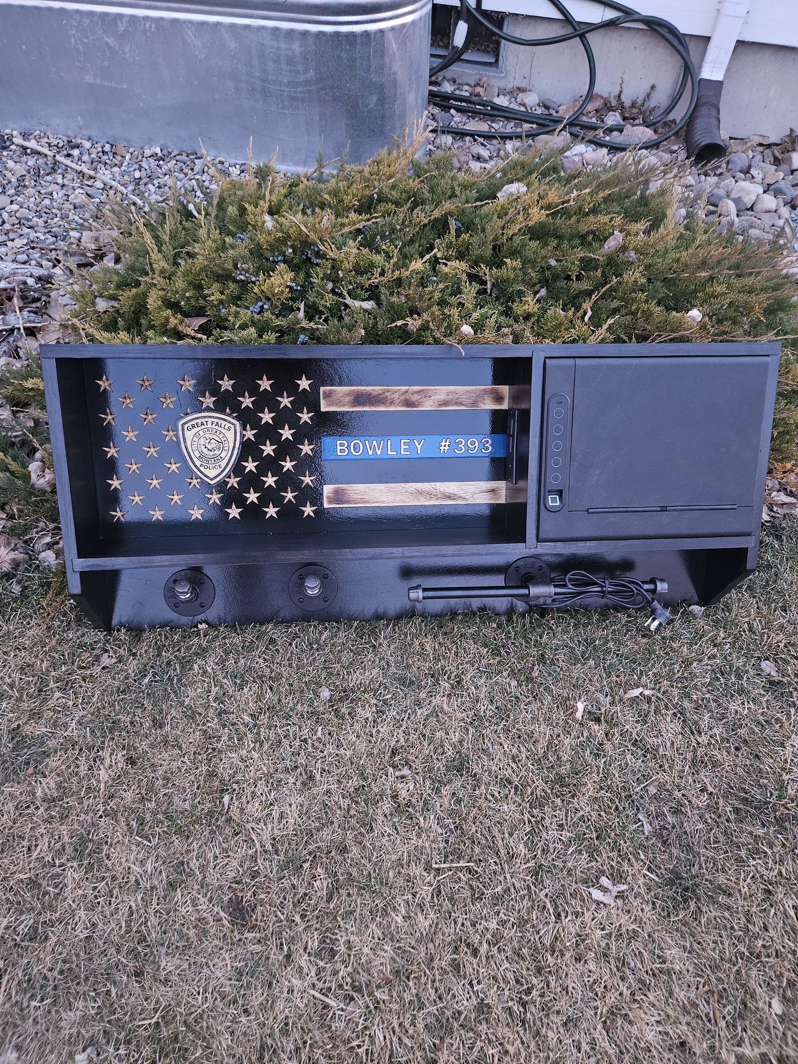 Thin blue line flag box with badge, displayed outdoors