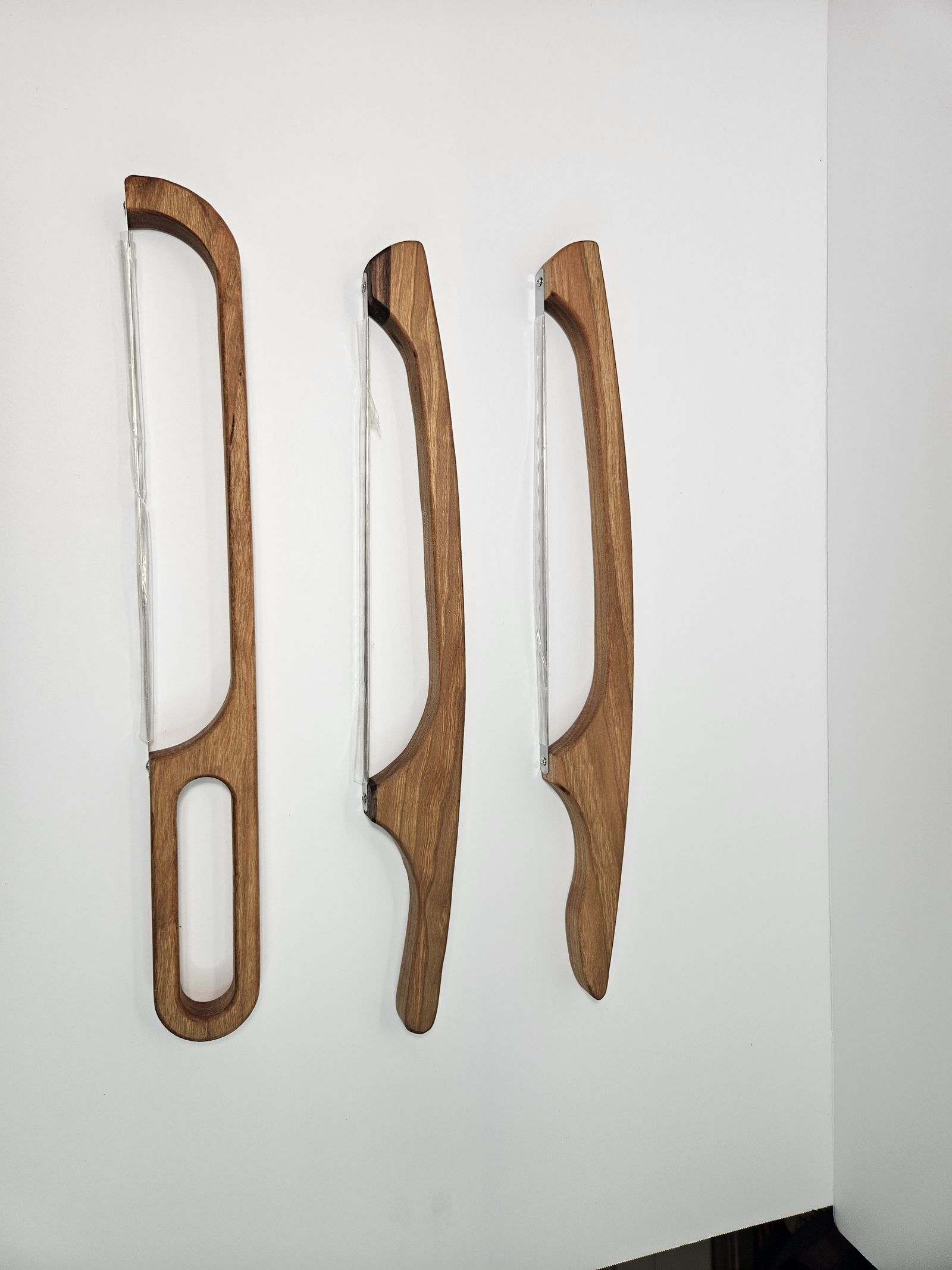 Three bread bow knives hanging on a wall