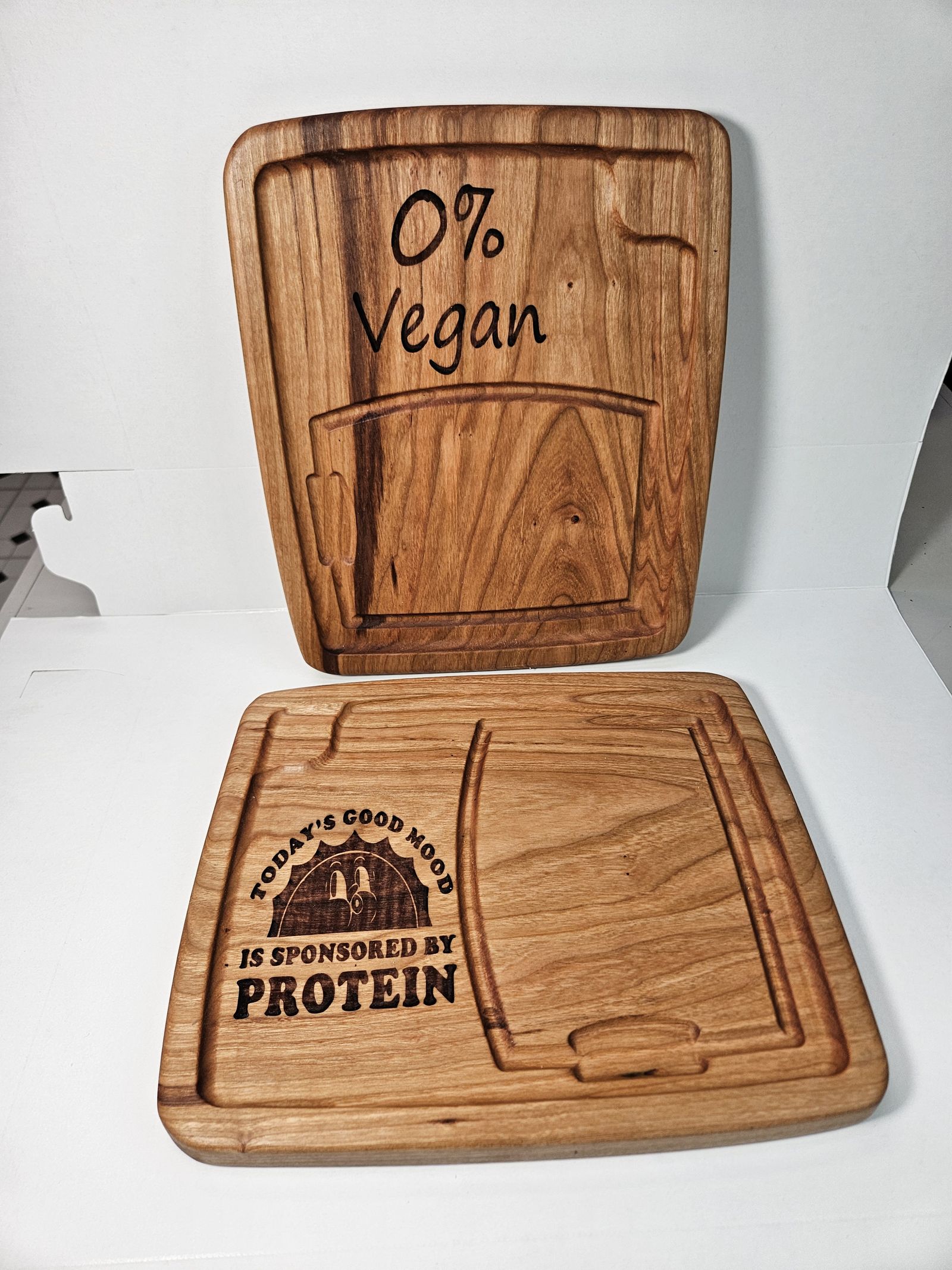 Two wooden steak plates with engraved sayings