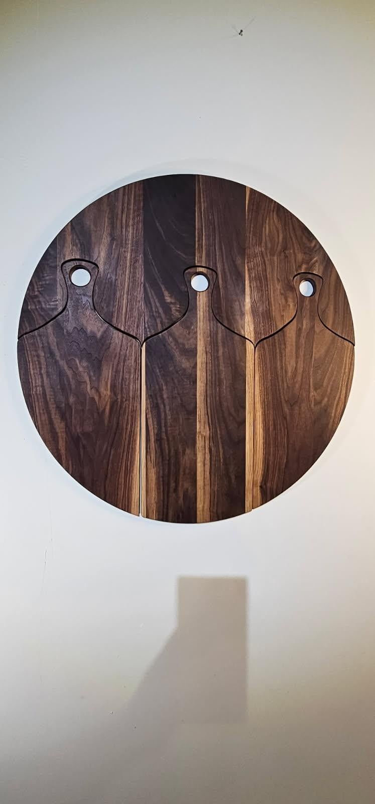 Nested walnut cutting board set in solid black walnut, hanging on a wall as round art
